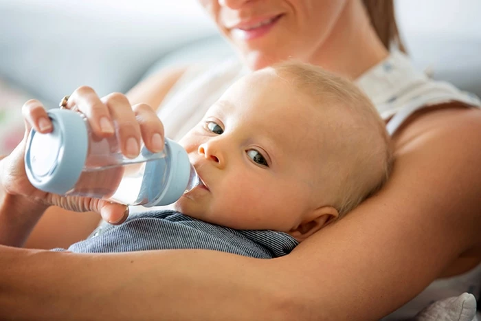 Cho trẻ sơ sinh uống nước bằng bình, thìa hoặc cốc để giúp bé uống dễ dàng hơn.
