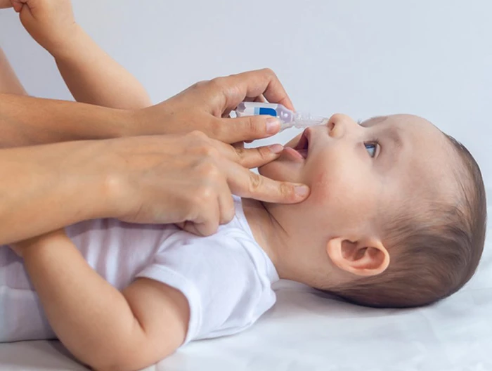 Vệ sinh mũi cho trẻ bằng nước muối xịt hoặc nhỏ mũi